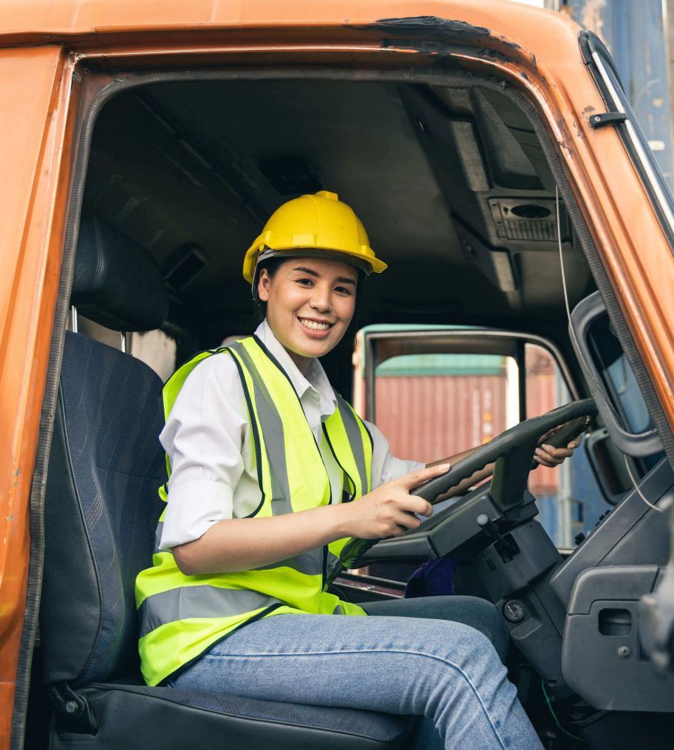 Woman with hard had on in truck smiling